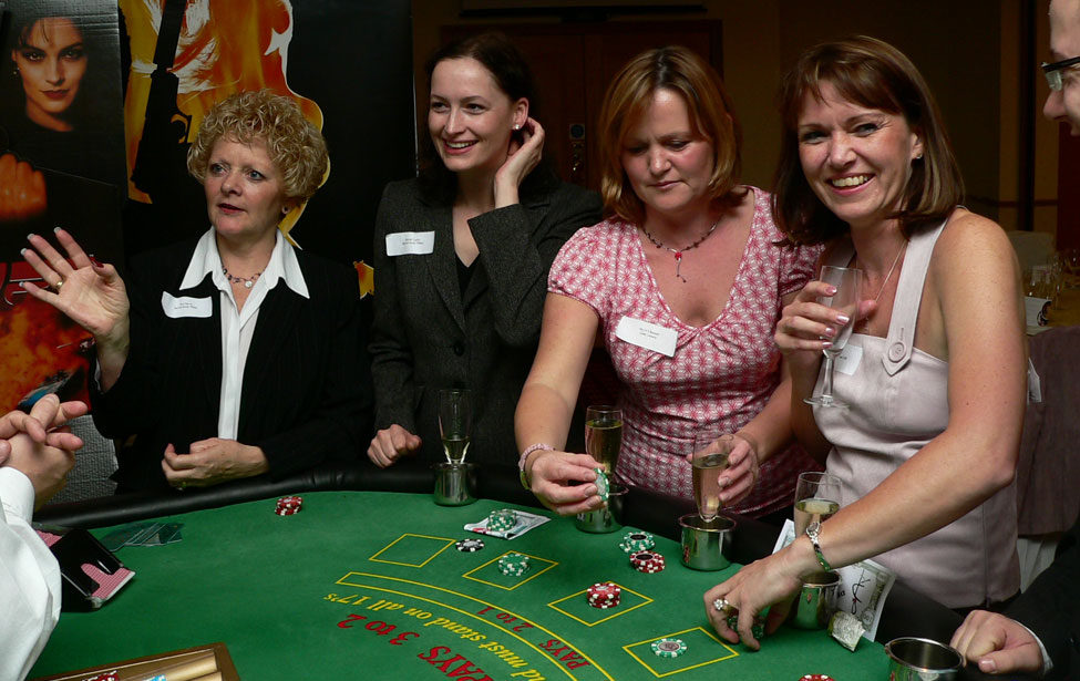 Corporate guests enjoying the dealer's company at the Blackjack Table during a James Bond Casino Party